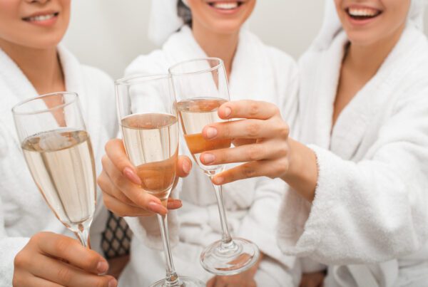 Clink glasses with champagne. Close-up of drinks in the hands of women relaxing in a spa